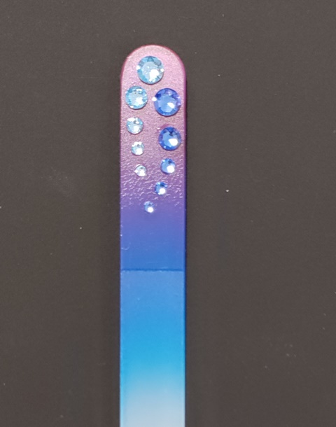 Nagelvijl met blauwe Swarovski steentjes op een van roze naar lichtblauwe achtergrond