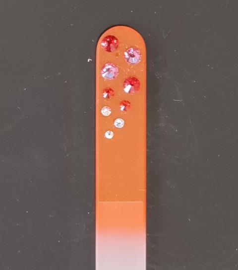 Nagelvijl met rode/transparante Swarovski steentjes op een oranje achtergrond