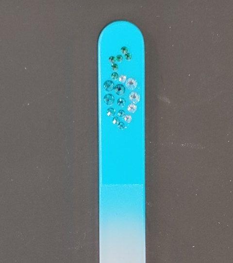 Nagelvijl met Swarovski druiventros op een lichtblauwe achtergrond