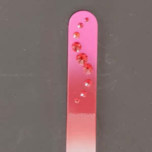 Nagelvijl met roze/rode Swarovski steentjes op een roze/rode achtergrond