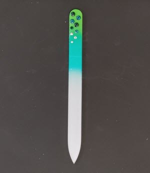 Nagelvijl met groene Swarovski steentjes op een licht-/donker-groene achtergrond